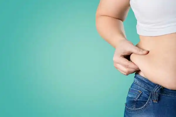 Image of woman pinching her love handles to show weight gain Surrey